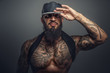© Fxquadro - Brutal tattooed man in black cap.
