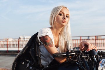 Biker woman sitting on vintage custom motorcycle