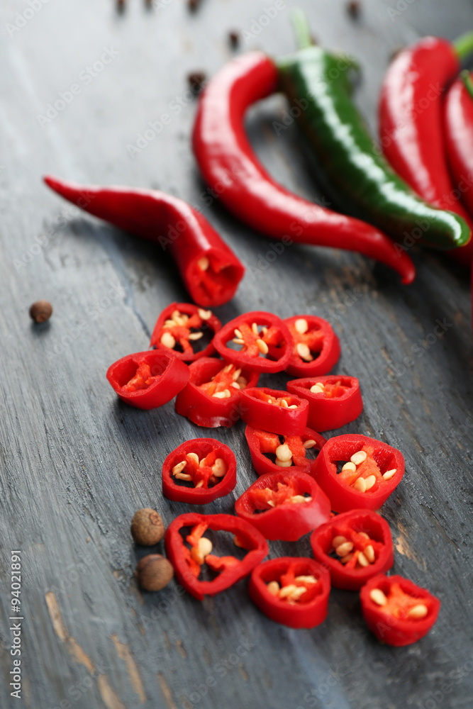Hot peppers with spices on wooden table close up