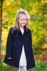 Wall Mural - Adorable little girl outdoors at beautiful warm day in autumn