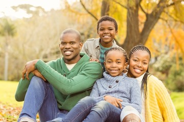 Wall Mural - Portrait of a young family sitting in leaves