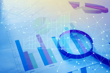 Magnifying glass and documents with analytics data lying on tabl