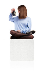 young woman desperate with an alarm clock sitting on a box