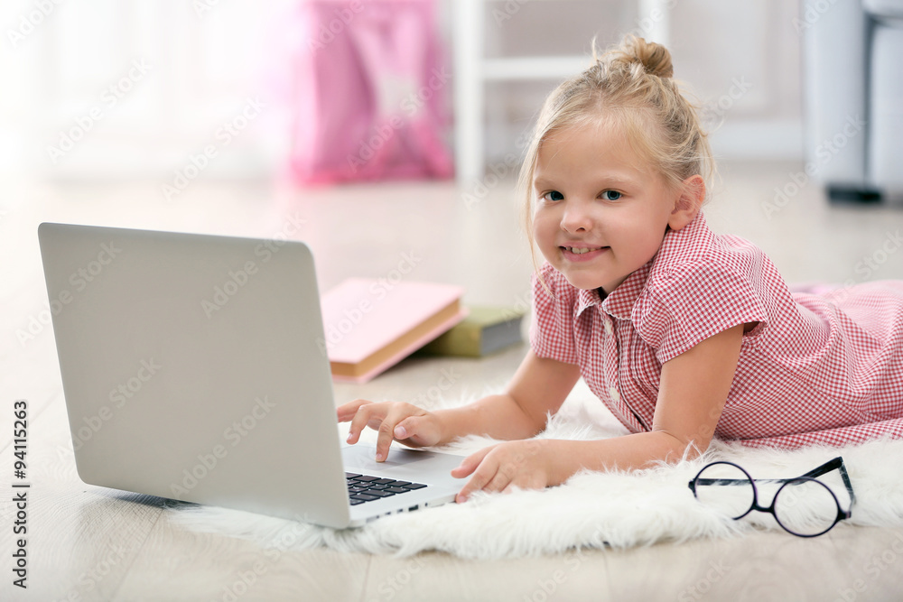 Little girl with laptop in the room