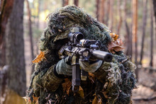 Sniper Aiming From His Rifle In Forest/Portrait Of Sniper In The Woods, Which  Aiming From His Rifle