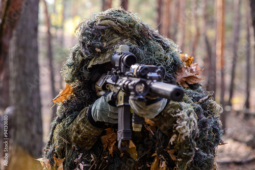 Cuadros en Lienzo Francotirador apuntando a partir de su rifle en el bosque / Retrato de francotir