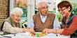 canvas print picture - Elderly couple and daughter, playing board game