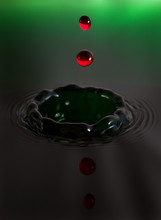 Beautiful Image Of A Drop Of Red Water Falling Into Green Water