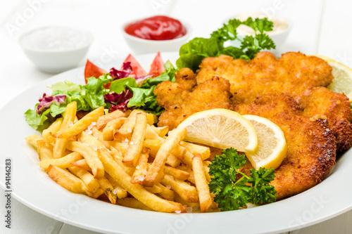 Fototapeta na wymiar Hähnchen Schnitzel mit Pommes und Salat