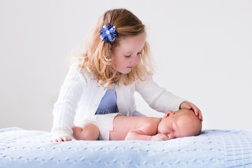 Wall Mural - little girl playing with newborn baby brother