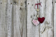 Skeleton key and rope hearts hanging on rustic wood door