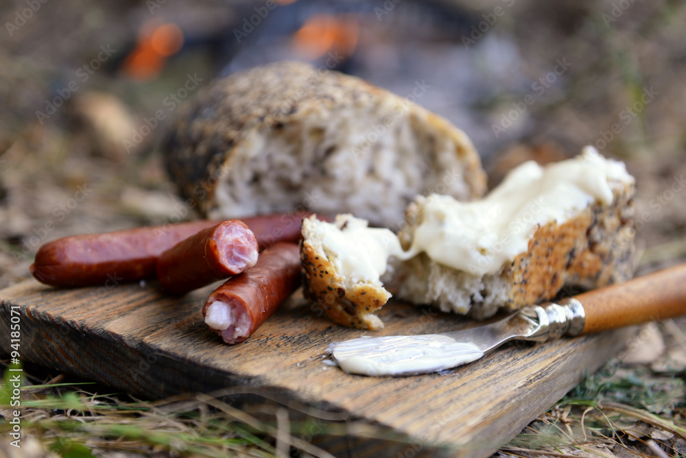 Grilled sausages on cutting board in the wood