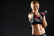 © Africa Studio - Athletic woman with dumbbell on dark background