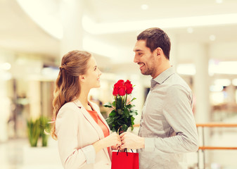 Wall Mural - happy young couple with flowers in mall