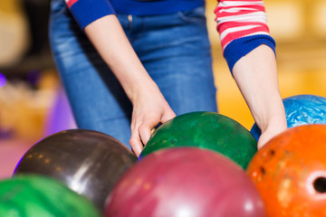  close up of woman hands choosing bowling ball