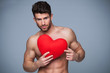 © pikselstock - Muscular man holding heart shape