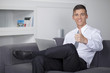 © COSPV - Young businessman showing hand gesture thumb up success sign sit
