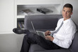 © COSPV - Happy businessman working with a notebook and sitting on couch i