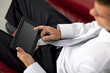 © COSPV - Happy young businessman holding and touching a digital tablet and sitting on couch