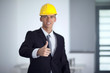 © COSPV - Successful businessman with yellow helmet poses and hand gesturi