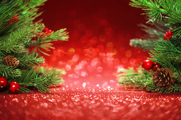 christmas tree branches on glittering red background