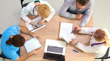 Male and female doctors working on reports in medical office