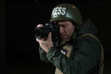 Photojournalist in a helmet and flak jacket wore protective equipment for shooting in hot spot