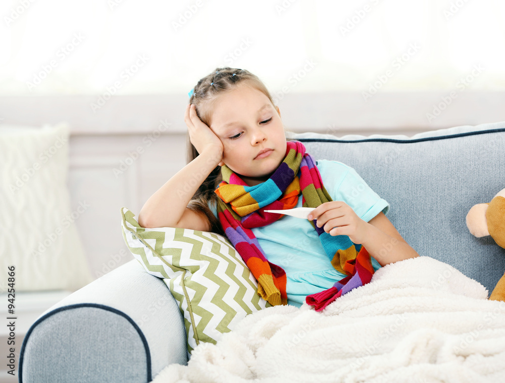 Sick girl with cold sitting on sofa