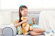 © Africa Studio - Beautiful little girl with teddy bear sitting on sofa, on home interior background