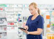 © Tyler Olson - Female Chemist Using Digital Tablet In Pharmacy
