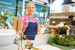 © Tyler Olson - Smiling Florist Using Laptop At Counter In Flower Shop