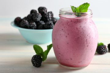 Wall Mural - Delicious berry smoothie with blackberries on wooden table close up