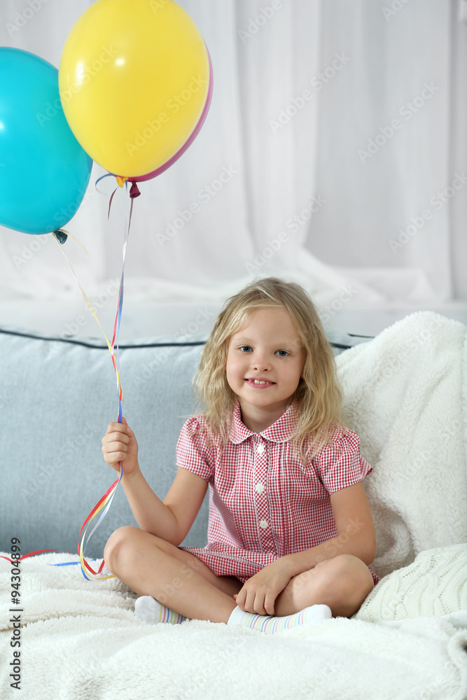 Little girl with balloons in the room
