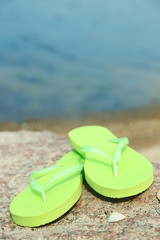 Sticker - Bright flip-flops on stone, nature background