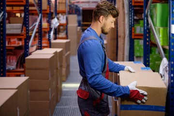 Wall Mural - Porter carrying boxes in a warehouse