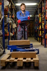 Wall Mural - Loader using hand pallet truck in a warehouse