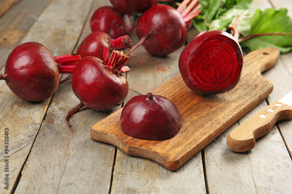 Young beets with leaves on wooden table close up