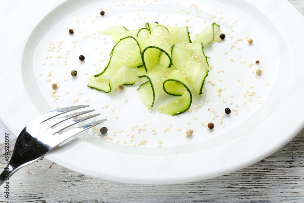 Sliced cucumbers dish on white plate in the restaurant, close up