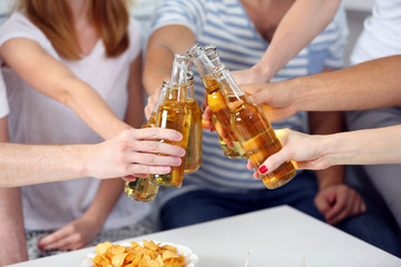 Wall Mural - Friends hands with bottles of beer and snacks , close up