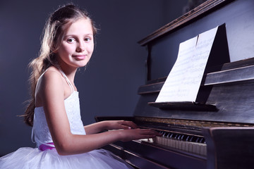 Poster - Cute little princess girl plays piano in the dark room