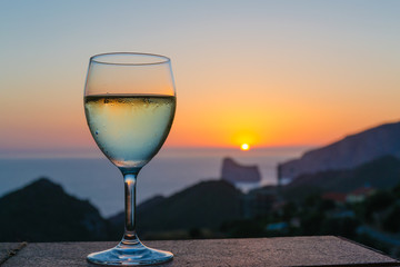 The glass of white wine in the sunset