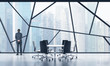 © ImageFlow - Rear view of a full length man in a formal suit who is looking out the window in a modern panoramic meeting room in Singapore. The concept of highly professional financial or legal services.