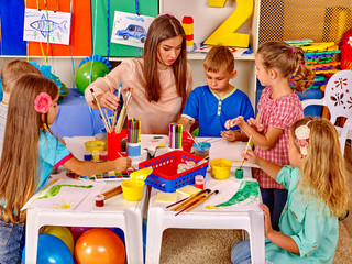 group children with teacher in preschool kindergarten .