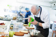 © mrcats - Baker prepares a cake and eclairs