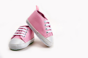 Pink baby girl shoes on a wooden floor outdoors