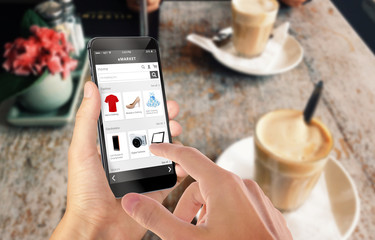 Poster - Smart phone online shopping in man hand. Desk with caffe in background. Buy clothes shoes accessories with e commerce web site