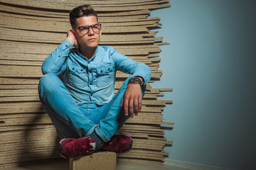 Wall Mural - young man sitting in studio with legs crosses