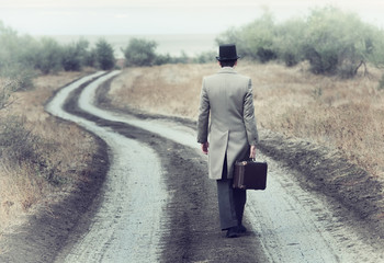 Retro style man on the country road, view from back