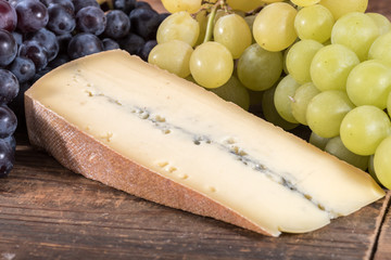 Wall Mural - French morbier cheese with black and white grapes