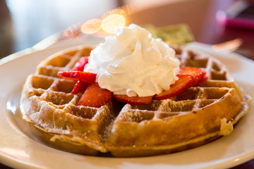 whipped cream on strawberries on waffle